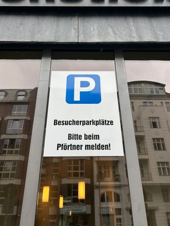 Schild für Besucherparkplätze bitte beim Pförtner melden